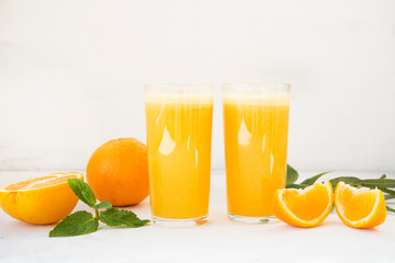 Two glasses of freshly squeezed orange juice on white background
