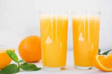 Two glasses of freshly squeezed orange juice on white background