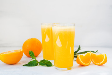 Naklejka na ściany i meble Two glasses of freshly squeezed orange juice on white background