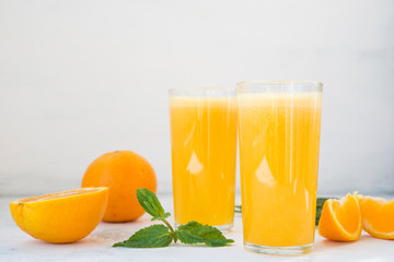 Two glasses of freshly squeezed orange juice on white background