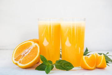 Two glasses of freshly squeezed orange juice on white background