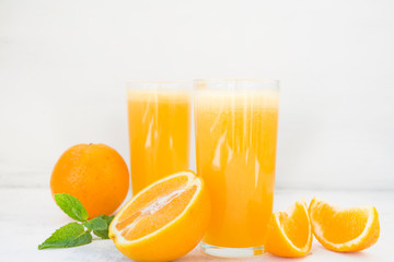 Two glasses of freshly squeezed orange juice on white background