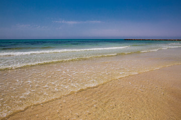 Fototapeta na wymiar Soft blue ocean wave on sandy beach. Bottom. White sand on the beach with turquoise water in Djerba, Tunisia.