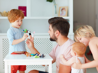 happy father playing with kids at home, funny puppet games