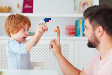 happy father playing with kid at home, funny puppet games, animal impersonated