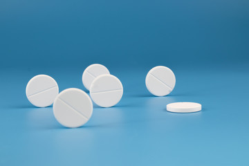White big pills on a blue background.