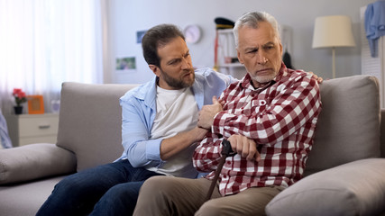 Middle-aged male comforting retiree father, suffering loss of wife, depression