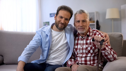 Happy smiling father and son looking at camera, social insurance, statistics