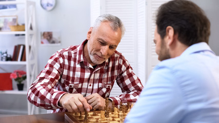 Father and son competing in chess, weekend hobby and leisure activity, tradition