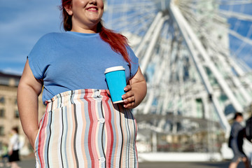 Young and fat woman with paper cup in the city