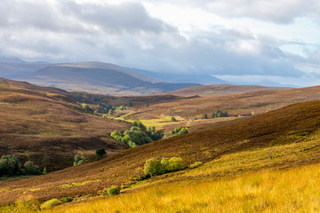 A scenic view of red and brown hills and highlands in Cairngorms national park, Scotland