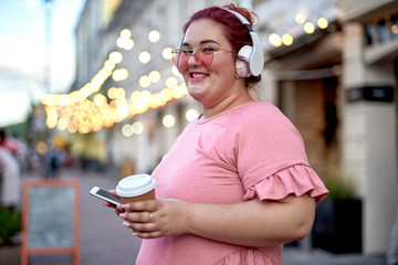 Young and fat woman with smartphone in city