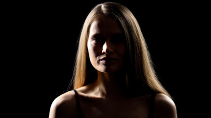 Pretty female looking at camera and smiling, isolated on black background