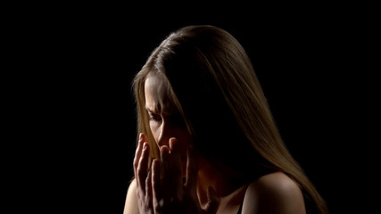 Obraz premium Desperate woman hiding face behind hands, family assault victim, sexual slavery