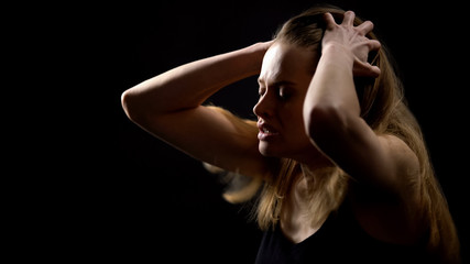 Nervous woman holding head, trying to relieve stress, negative emotions, abuse