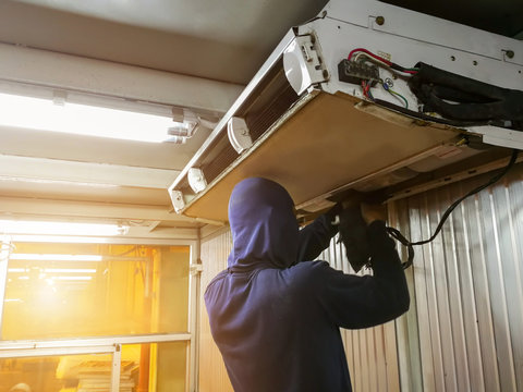Male technician checking and fixing air conditioner indoors,maintenance and repair