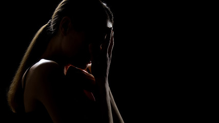 Lady crying against black background, feeling frustrated, pain of relative loss