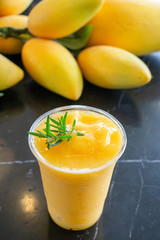 Naklejka na ściany i meble Top view of Fresh Sweet Mango juice in plastic glass.Summer Drink in Thailand.