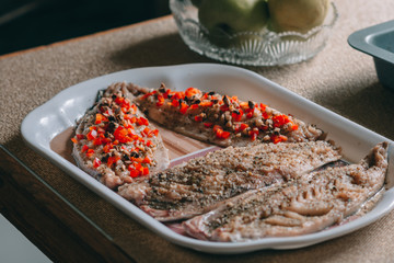 Raw fishes and vegetables on stone background, copy space.
