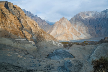 Aerial nature landscape view of mountain peaks in Karakoram range near moraine and glacial lake that melt from Passu glacier, Gojal Valley Hunza. Gilgit Baltistan, Pakistan.