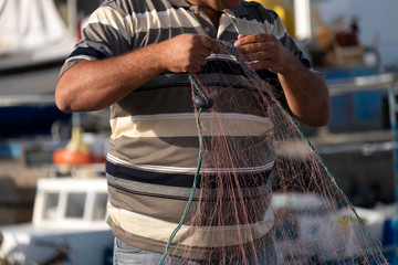 Old Fishermen are repairing fishing nets.Fishermen are cleaning fishing nets