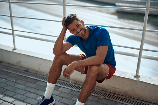 Adult sportsman smiling and resting after outdoor training