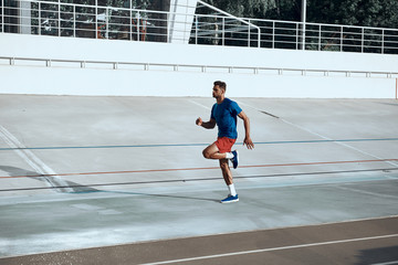 Sporty man running on stadium in city
