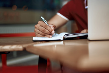 Close up of man writing notes in agenda