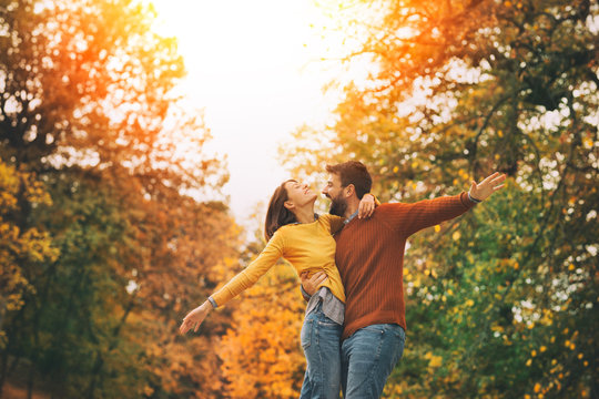 Young happy couple having fun in autumn park
