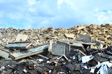 Landfill of old stones and concrete slabs from destroyed buildings. Recycling, shredding, crusher and processing asphalt concrete, stones and rebar shredder. Secondary crushed stone, background