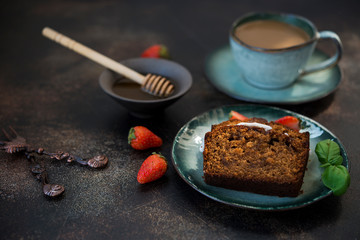 Two pieces of delicious honey cake with a Cup of coffee on a dark concrete background. Copy space