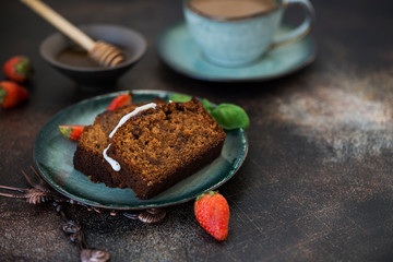Two pieces of delicious honey cake with a Cup of coffee on a dark concrete background. Copy space
