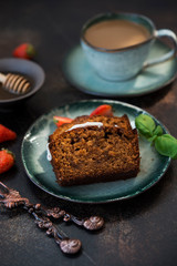 Two pieces of delicious honey cake with a Cup of coffee on a dark concrete background. Vertical orientation