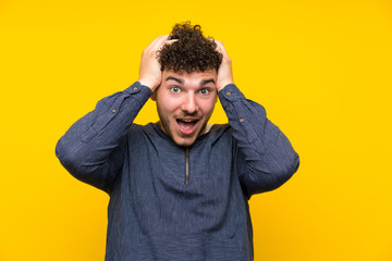 Young man over isolated yellow wall with surprise facial expression
