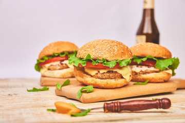 Craft beef burger  on wooden table on light background. Street food, fast food. Homemade juicy burgers with cheese and  on the wooden table. Copy space.