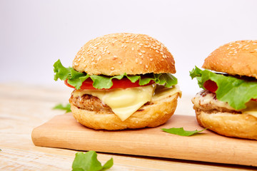 Craft beef burger  on wooden table on light background. Street food, fast food. Homemade juicy burgers with cheese and  on the wooden table. Copy space.