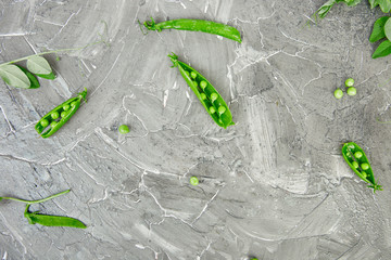 Flat lay composition with delicious fresh green peas on grey background. Vegan and vegetarian food concept.