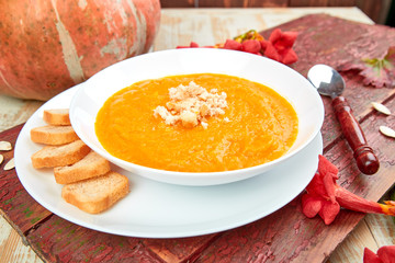 Cream of pumpkin soup on a white wooden background.  Diet vegetarian pupmkin soup puree. View from above, flat lay. Rustic. Thanksgiving Day.