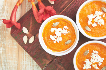 Cream of pumpkin soup or souffle on a white background.  Thanksgiving Day. Diet vegetarian pupmkin soup puree. View from above, flat lay. Rustic. Copy space.