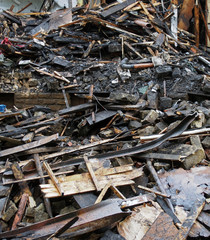 a heap of burned and scattered bricks beams and rubble after a fire in a large building