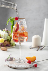 glass of wine with peaches ice and mint