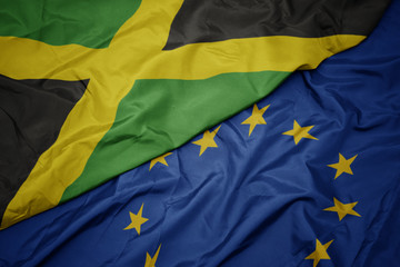 waving colorful flag of european union and flag of jamaica.