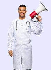 Young afro american man doctor holding a megaphone on isolated background