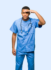 Surgeon doctor man looking far away with hand to look something on isolated background