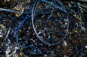 Steel scrap materials recycling. Aluminum chip waste after machining metal parts on a cnc lathe. Closeup twisted spiral steel shavings. Small roughness sharpness, possible granularity, blurred focus