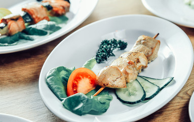 kebab and fresh vegetables on a white plate on the table