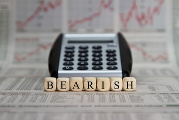 Bearish stock market with calculator on a busibess newspaper background