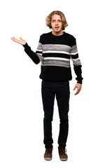 Obraz premium Full-length shot of Blonde man holding copyspace imaginary on the palm to insert an ad over isolated white background