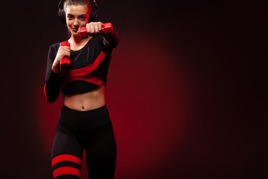 Sporty Fit Woman, Athlete With Dumbbells Makes Fitness Exercising On Red Background. Fitness And Workour Motivation.