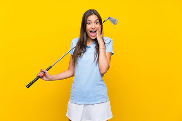 Young golfer woman over isolated yellow wall with surprise and shocked facial expression